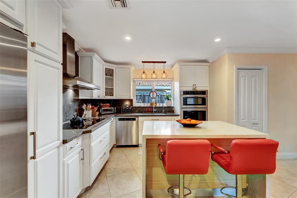 1500 Northeast 24th Street Wilton Manors, FL 33305 - Photo 40 of 88 a kitchen with stainless steel appliances granite countertop a stove top oven a sink dishwasher and cabinets with wooden floor