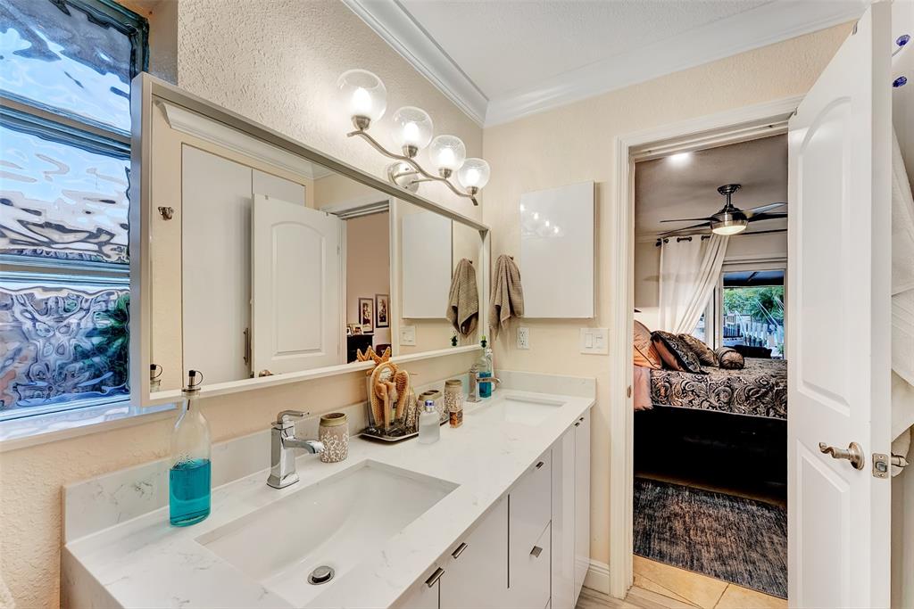 1500 Northeast 24th Street Wilton Manors, FL 33305 - Photo 48 of 88 a bathroom with a sink double vanity and a mirror
