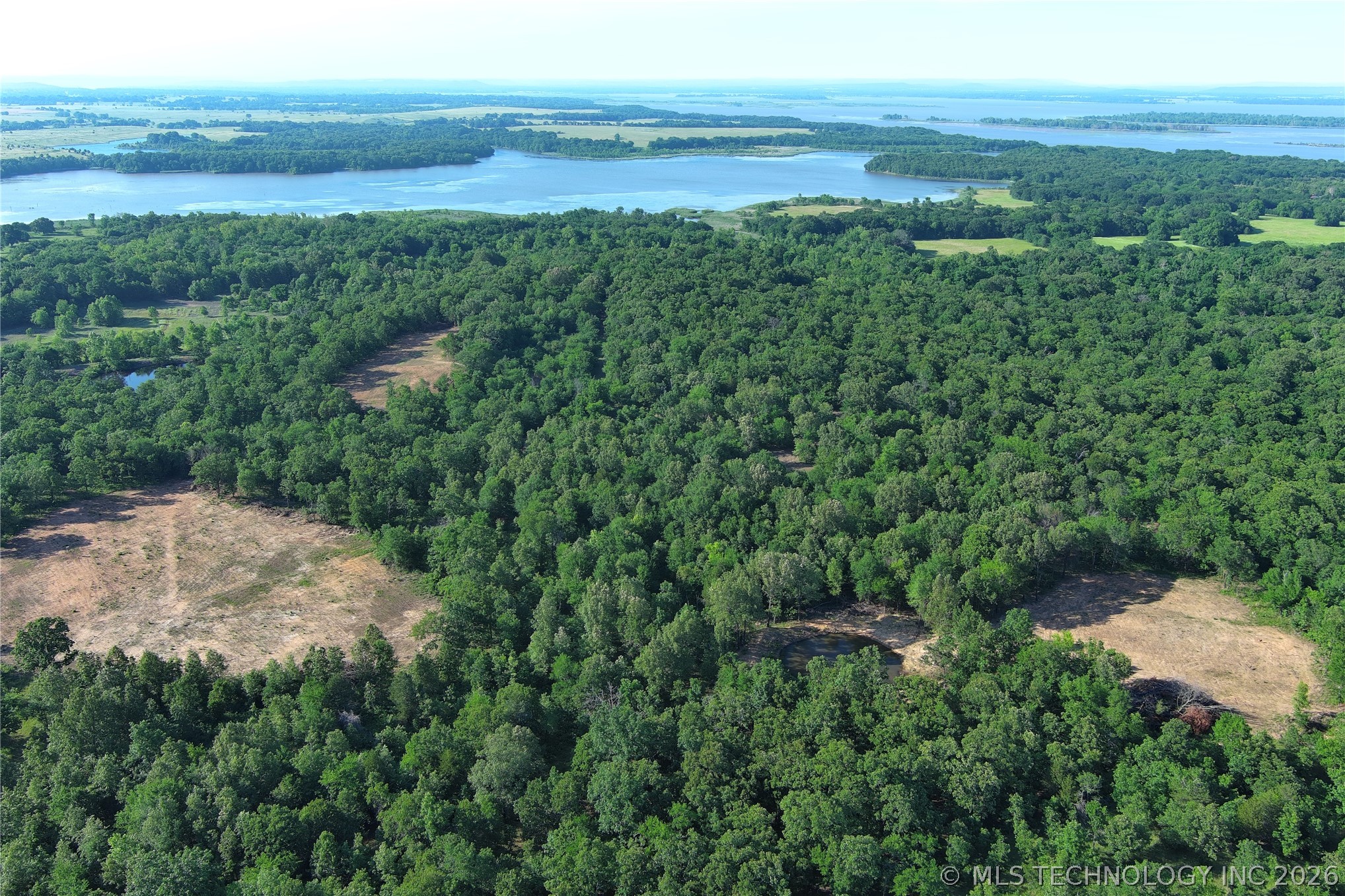 20862 East 1160th Road Keota, OK 74941 - Photo 5 of 47 Expansive forested property featuring multiple cleared areas, a natural pond, and distant lake access
