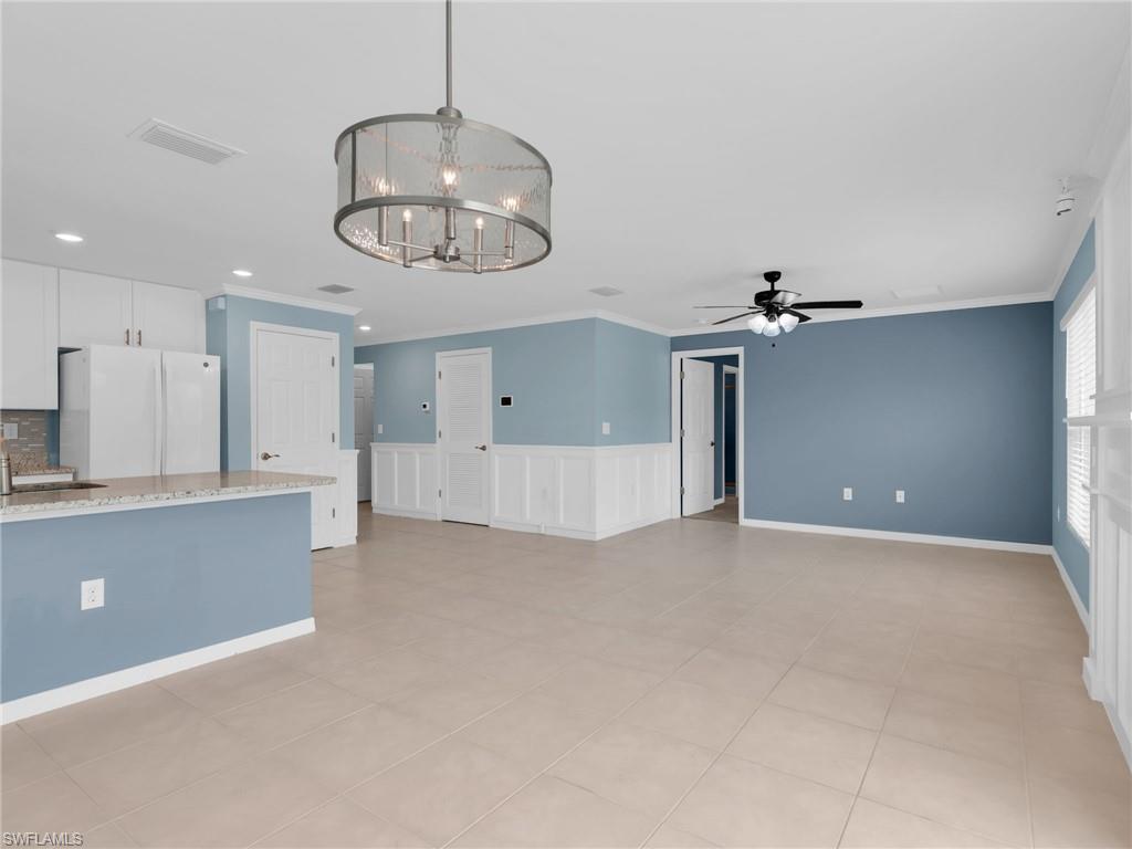 731 Hadley Place West Naples, FL 34104 - Photo 17 of 30 Great Room and Dining Area With Crown Molding, Chandelier, and Ceiling Fan, Kitchen With Island With Granite Countertop And Sink, White Shaker Cabinets, New White GE Dishwasher, Microwave, And Refrigerator, With Icemaker, And Stainless Steel Frigidaire Range With Self-Cleaning Oven