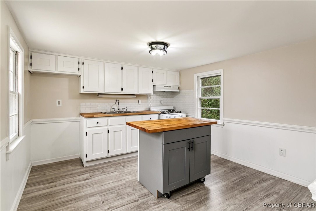 10370 Maryus Road Hayes, VA 23072 - Photo 17 of 35 Kitchen with white gas range oven, light hardwood / wood-style floors, sink, butcher block countertops, and white cabinetry