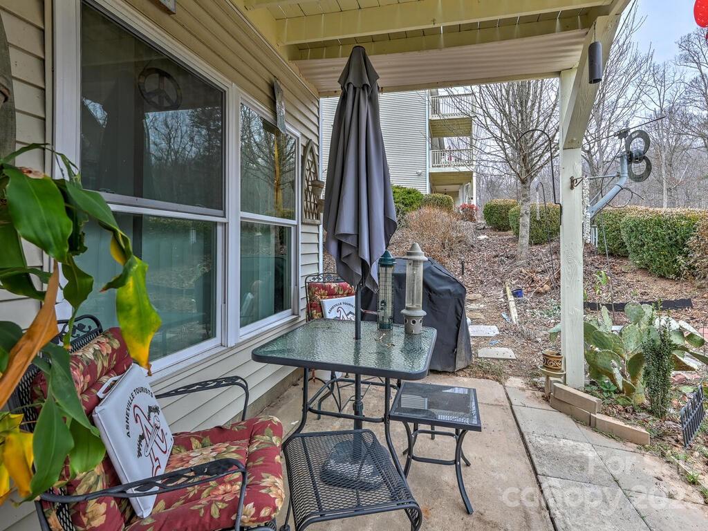 19 Krista Circle, Unit E Candler, NC 28715 - Photo 15 of 23 a view of a patio with table and chairs potted plants with wooden floor and fence
