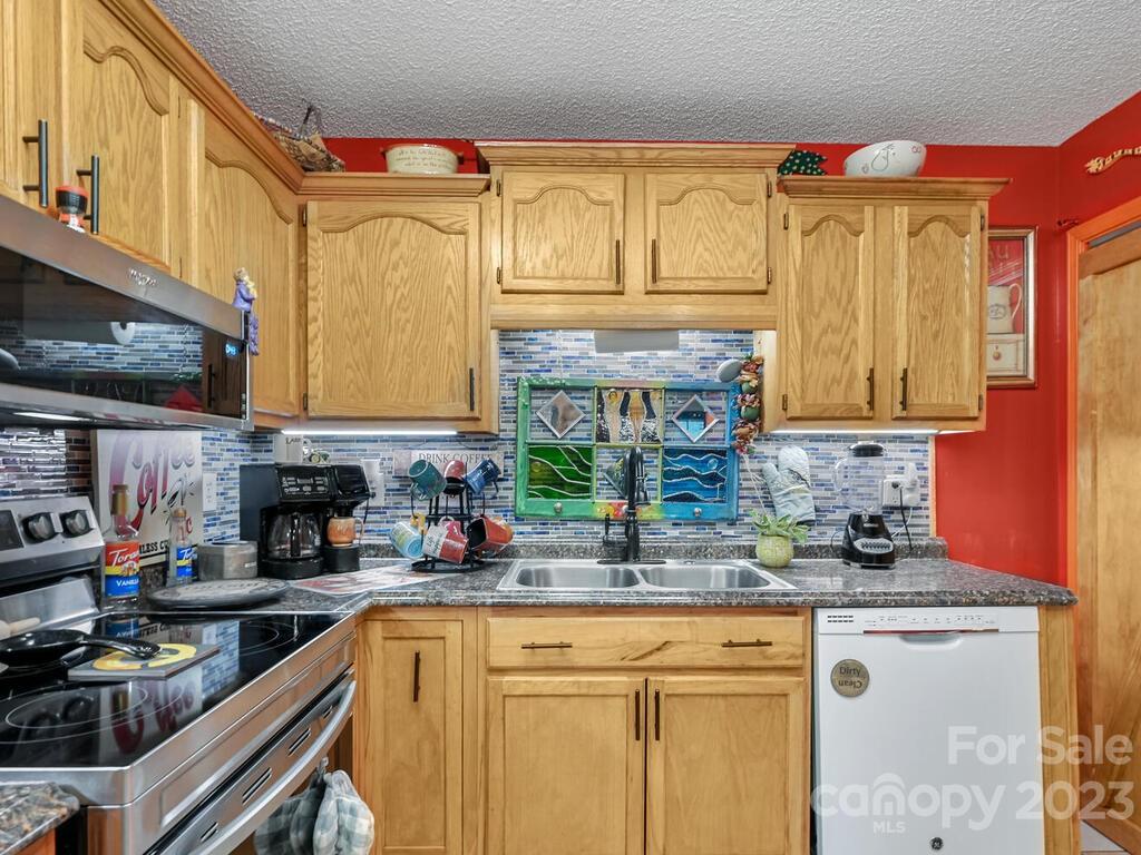 19 Krista Circle, Unit E Candler, NC 28715 - Photo 9 of 23 a kitchen with stainless steel appliances granite countertop a sink and cabinets
