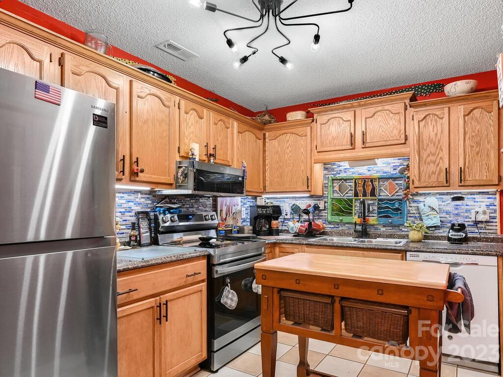 19 Krista Circle, Unit E Candler, NC 28715 - Photo 10 of 23 a kitchen with stainless steel appliances a refrigerator a sink a stove and cabinets