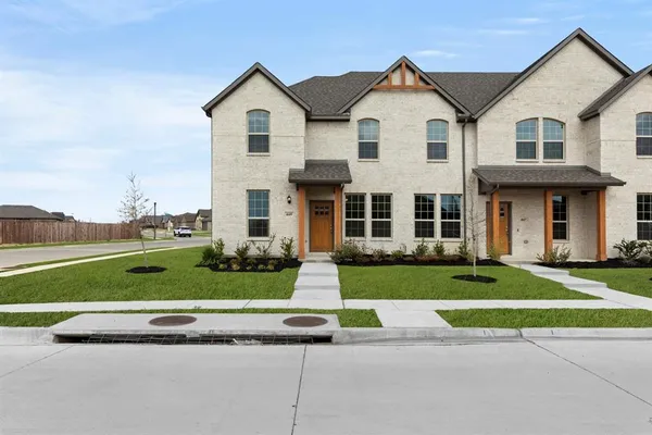 a front view of a house with a yard and trees