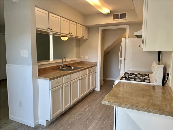 a kitchen with granite countertop a sink stove and cabinets