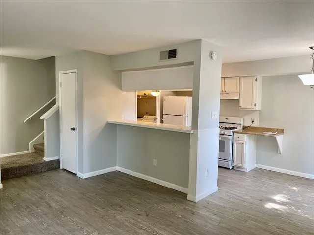 a kitchen with a refrigerator and a stove top oven