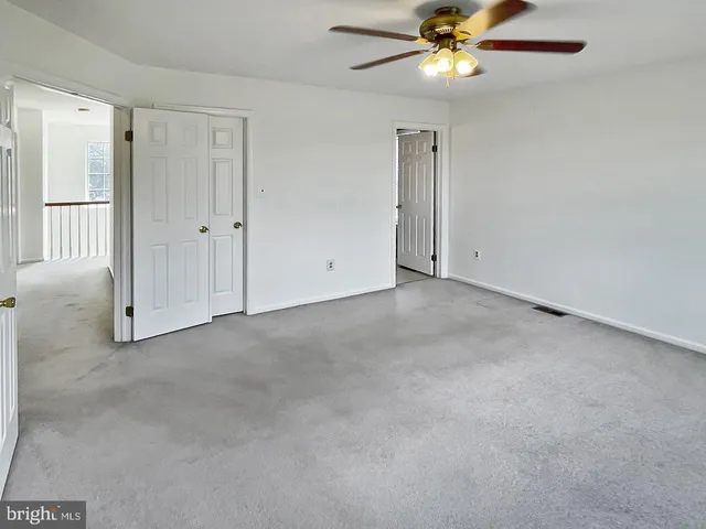a view of an empty room with a ceiling fan