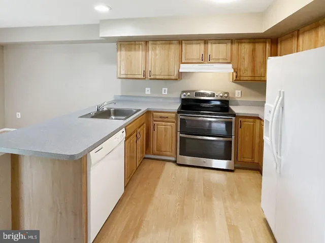 a kitchen with a stove top oven and sink