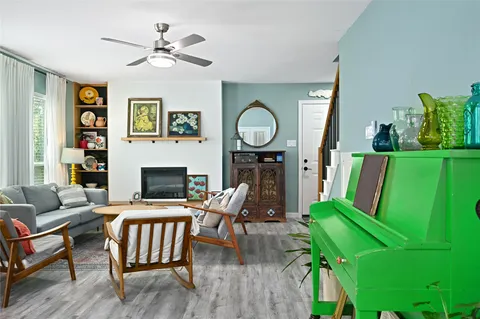 a living room with furniture a fireplace and a large window