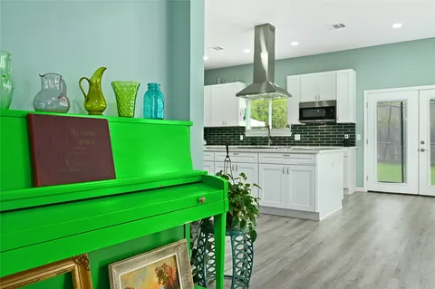 a kitchen with green cabinets stove and sink