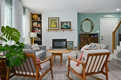 a living room with furniture a potted plant and a fireplace