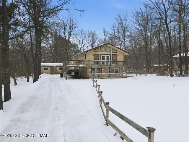 a view of a house with a yard covered in snow