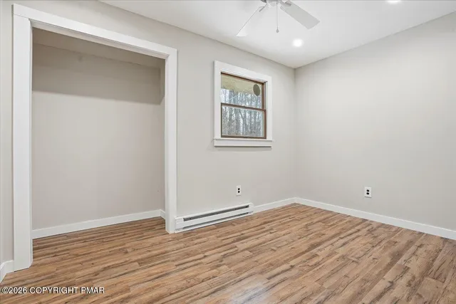 an empty room with wooden floor and closet