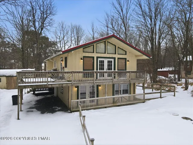 a view of a house with backyard and deck