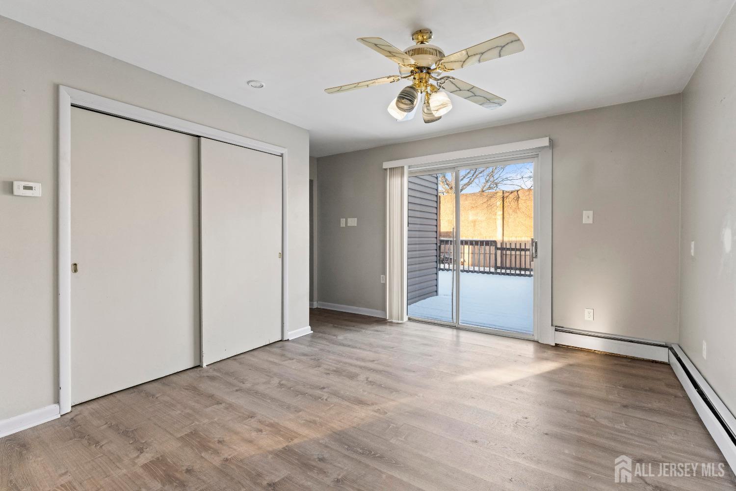 70 Central Avenue Sewaren, NJ 07064 - Photo 11 of 22 an empty room with wooden floor and a ceiling fan
