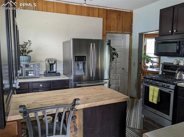 a kitchen with kitchen island a counter top space stainless steel appliances and cabinets