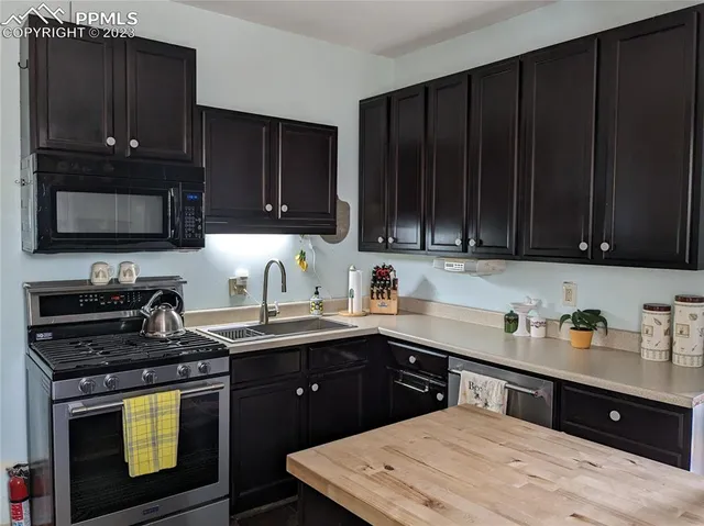 a kitchen with a sink a stove and cabinets