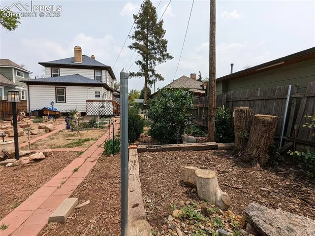 a view of a patio with table and chairs potted plants with wooden fence