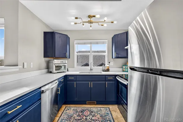 a kitchen with a sink a refrigerator and window