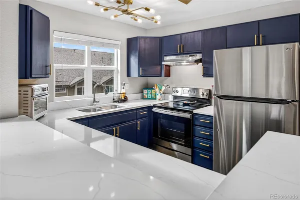 a kitchen with stainless steel appliances a refrigerator a sink a stove a microwave and island