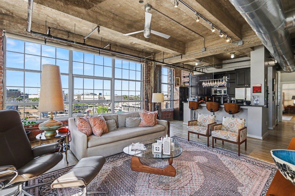 a living room with furniture kitchen view and a large window