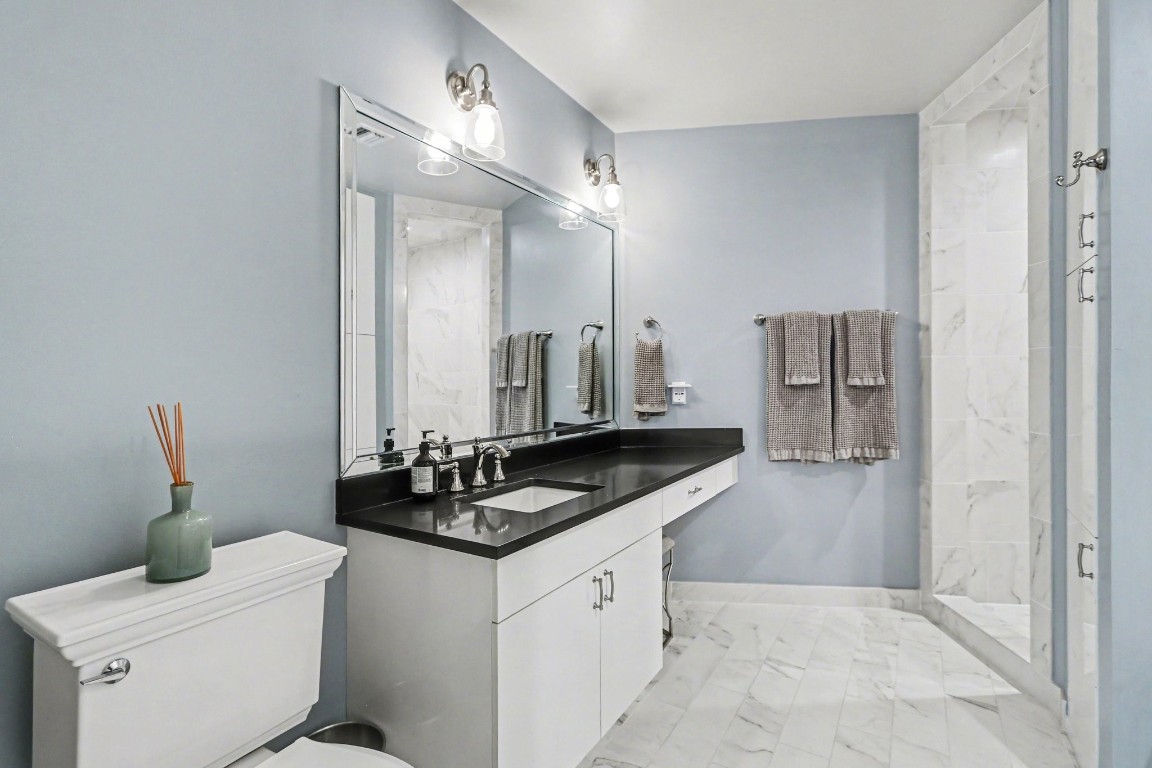 204 Travis Street, Unit 4E Houston, TX 77002 - Photo 19 of 29 a bathroom with a granite countertop sink a toilet and shower