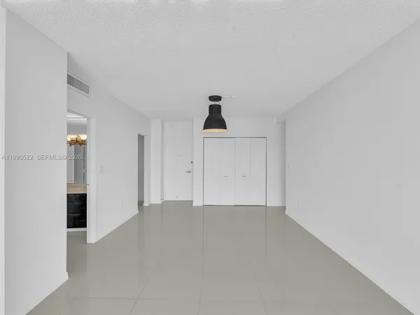 an empty room with a cabinet and a window