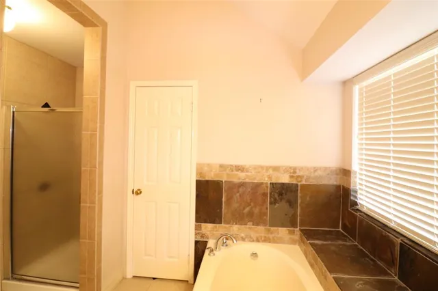 a bathroom with a bathtub and shower