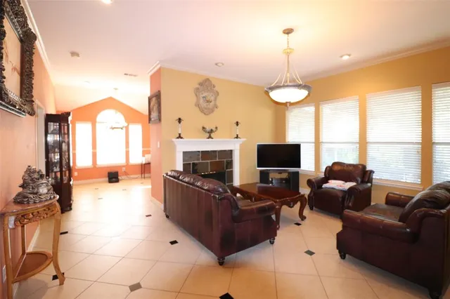 a living room with furniture a flat screen tv and a large window