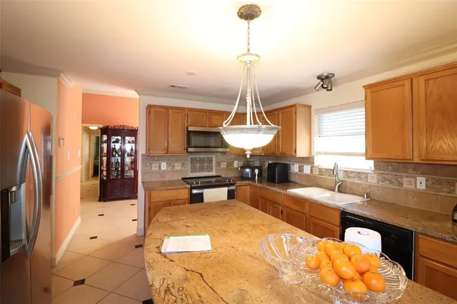 a large kitchen with kitchen island a counter space a sink stainless steel appliances and cabinets