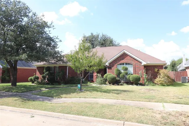 a front view of house with yard and trees around