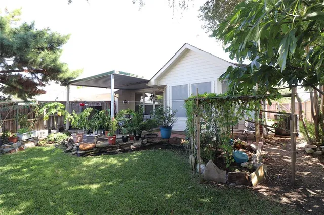 a view of a house with backyard sitting area and garden