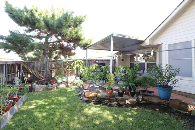a view of a chair and table in backyard of the house