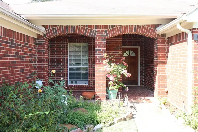 a front view of a house with a large tree