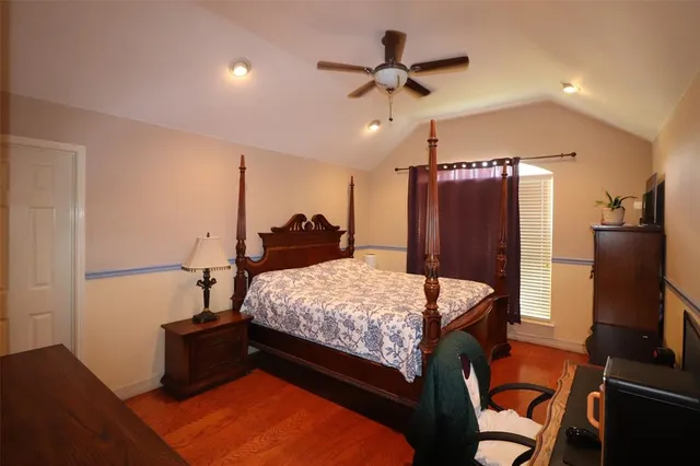 a bed room with a bed desk and a refrigerator