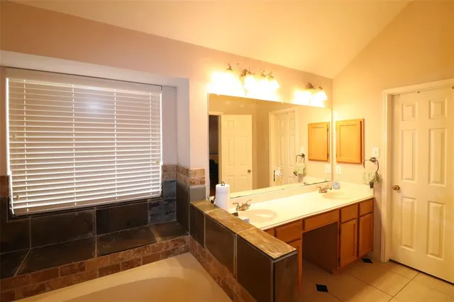 a bathroom with a tub sink and mirror