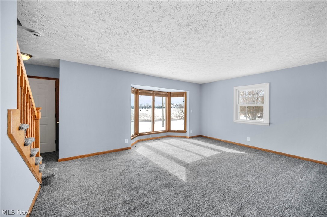 2099 Pontius Road Mogadore, OH 44260 - Photo 6 of 35 Spare room featuring a textured ceiling, plenty of natural light, and carpet floors