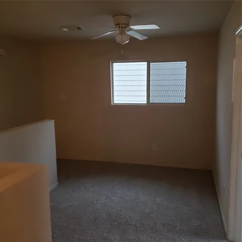 an empty room with a window and a ceiling fan