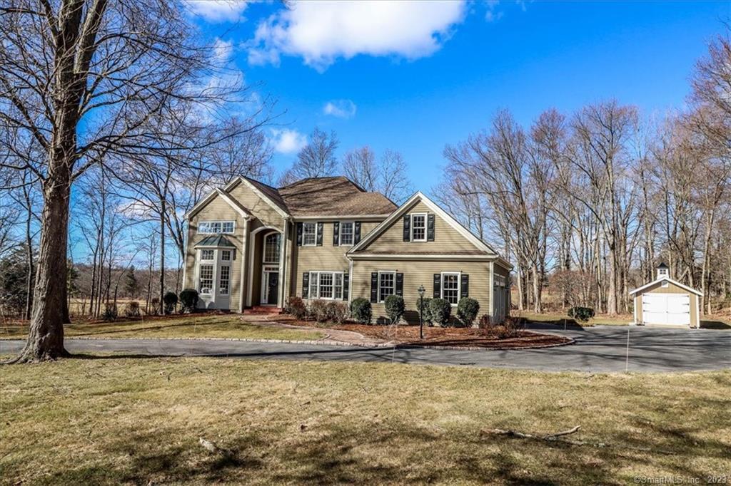 a front view of a building with trees around