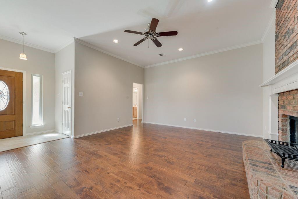 11374 Jennifer Circle Forney, TX 75126 - Photo 11 of 36 Living room with crown molding, ceiling fan, dark wood finished floors, a brick fireplace, and recessed lighting.