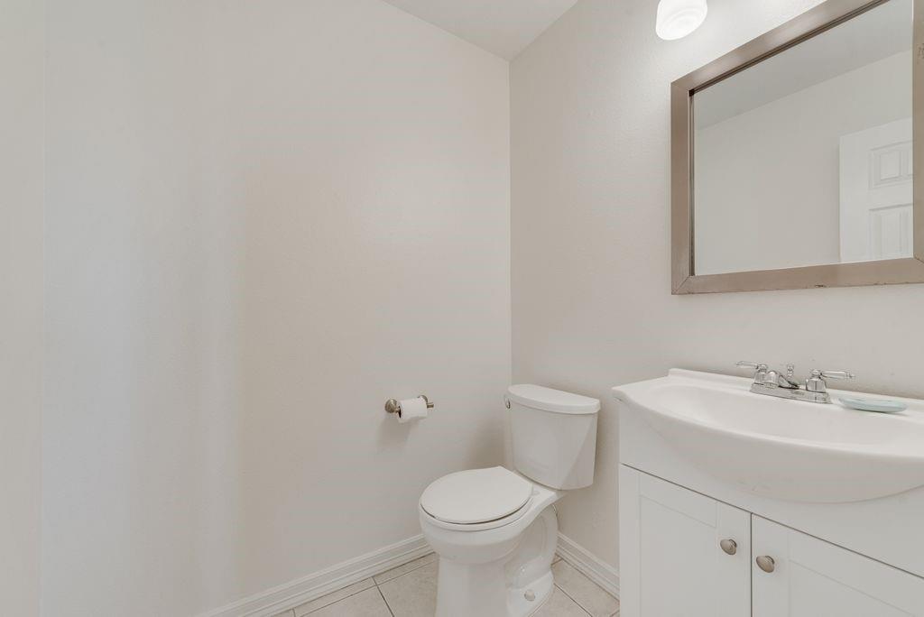 11374 Jennifer Circle Forney, TX 75126 - Photo 18 of 36 Half bath, right off the kitchen, with vanity and light tile patterned floors.