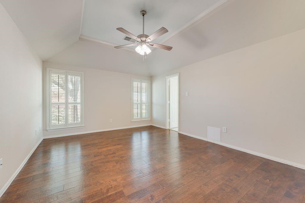 11374 Jennifer Circle Forney, TX 75126 - Photo 28 of 36 Master bedroom featuring dark wood-type flooring, ceiling fan, and lofted ceiling with entry into the on-suite.