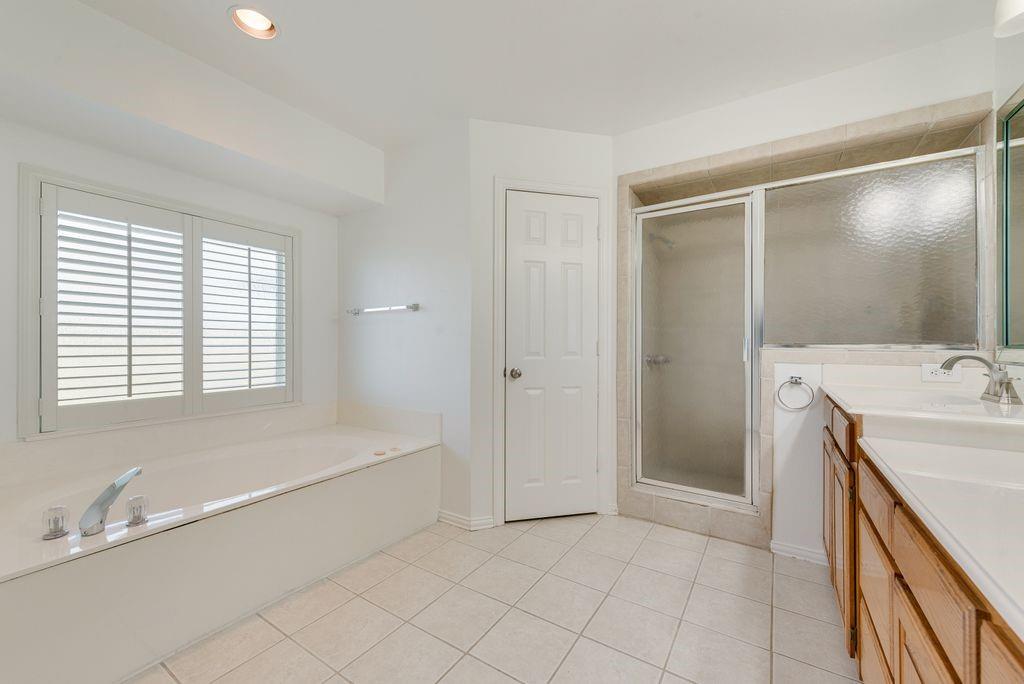 11374 Jennifer Circle Forney, TX 75126 - Photo 29 of 36 On-suite featuring double vanity, a jetted bath, a separate stall shower, light tile patterned floors, and recessed lighting. It has 2 walk in closets and a water closet.