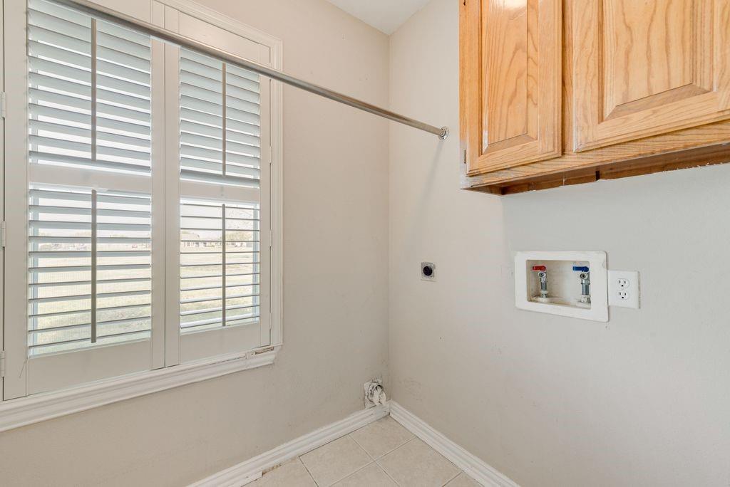11374 Jennifer Circle Forney, TX 75126 - Photo 31 of 36 Laundry room featuring hookup for a washing machine, light tile patterned floors, hookup for an electric dryer, and cabinet space.