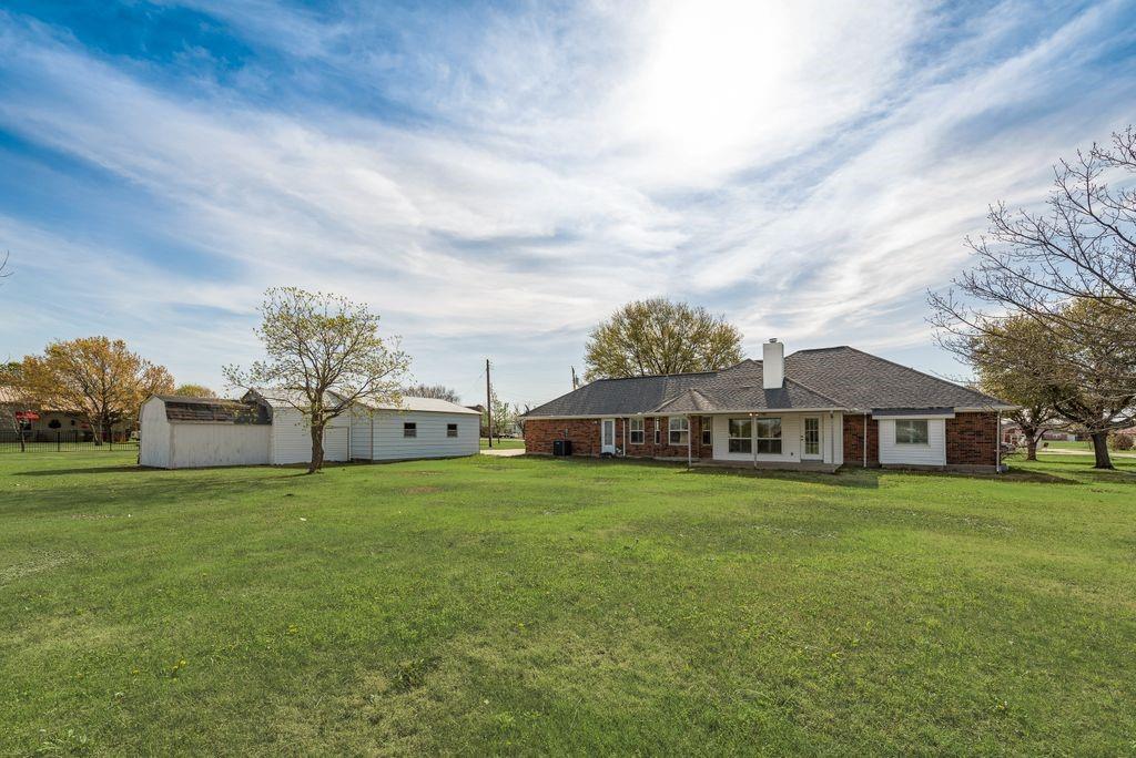 11374 Jennifer Circle Forney, TX 75126 - Photo 35 of 36 Rear view of property with 3 workshops, a yard, a patio area, and a chimney.