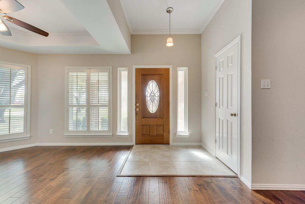 11374 Jennifer Circle Forney, TX 75126 - Photo 5 of 36 Foyer with ceiling fan, ornamental molding, dark wood-style floors, and plenty of natural light.
