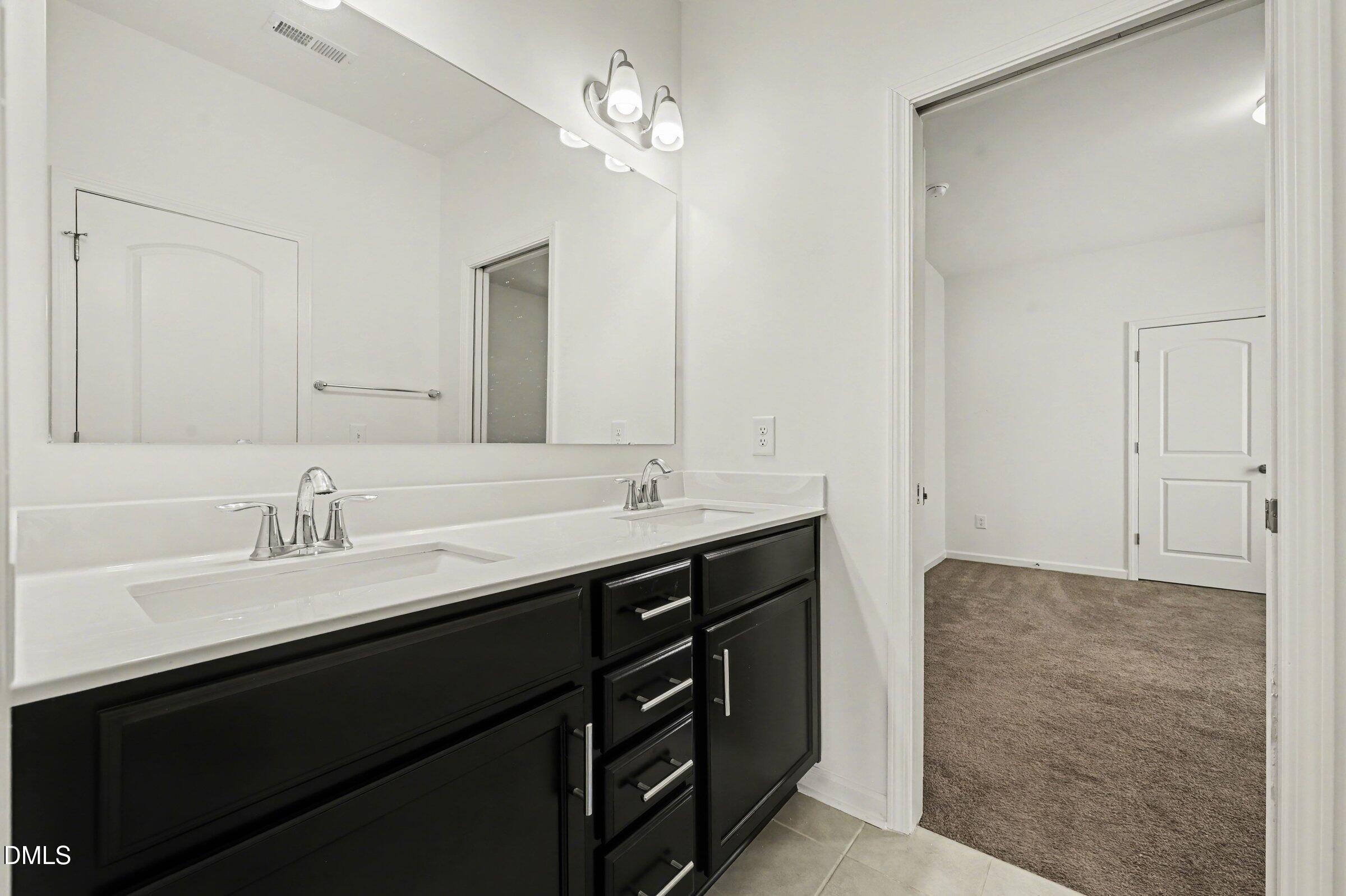7015 Grainfield Road Mebane, NC 27302 - Photo 32 of 42 a bathroom with a sink double vanity and a mirror
