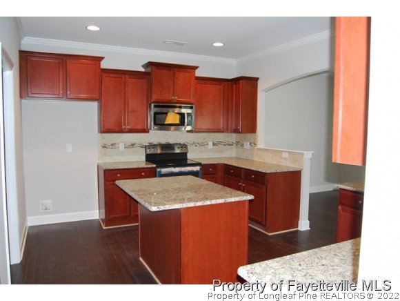 1024 Micahs Way North Spring Lake, NC 28390 - Photo 11 of 25 a kitchen with stainless steel appliances granite countertop a sink stove and refrigerator