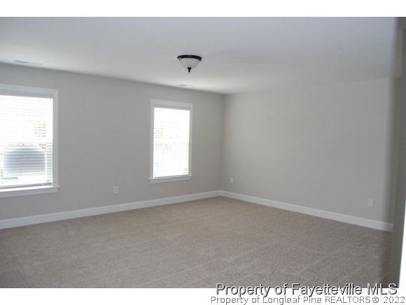 1024 Micahs Way North Spring Lake, NC 28390 - Photo 15 of 25 an empty room with wooden floor and windows
